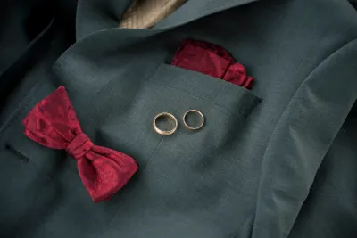 Ringe auf grauem Sakko mit roten Accessoires